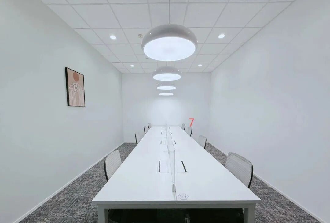 会议室实景,白色长桌与透明隔断